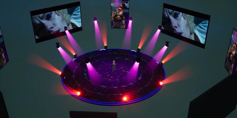 Stage lit by a ring of moving heads seen from above